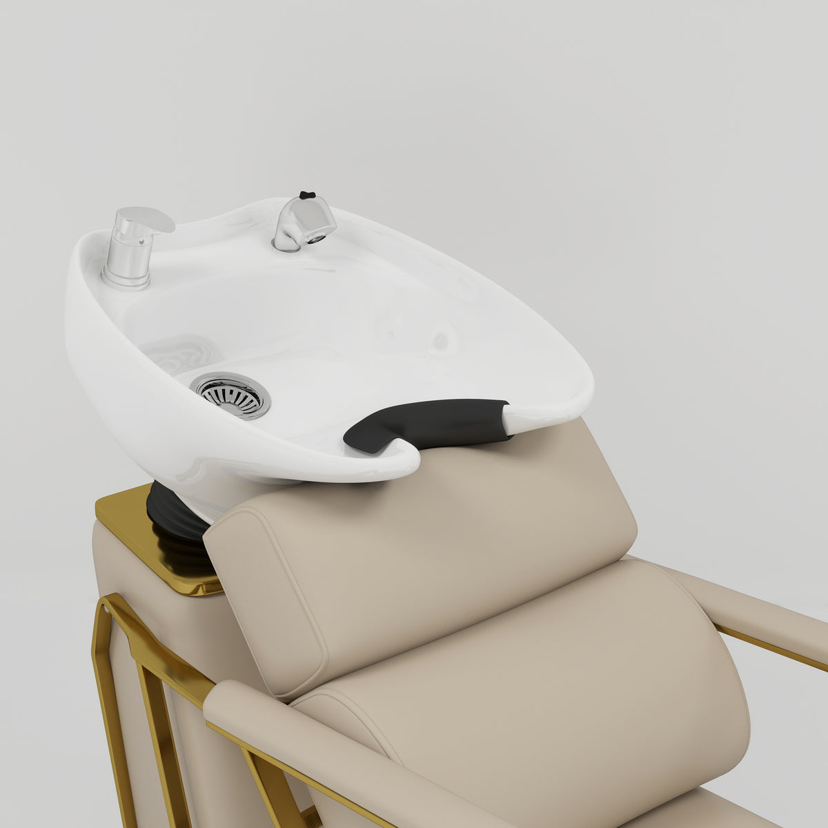 A white ceramic salon shampoo basin mounted on a beige leather chair with gold metal frame accents