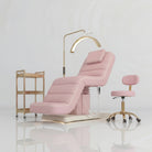 Pink leather salon bed with cream piping and gold accessorises 