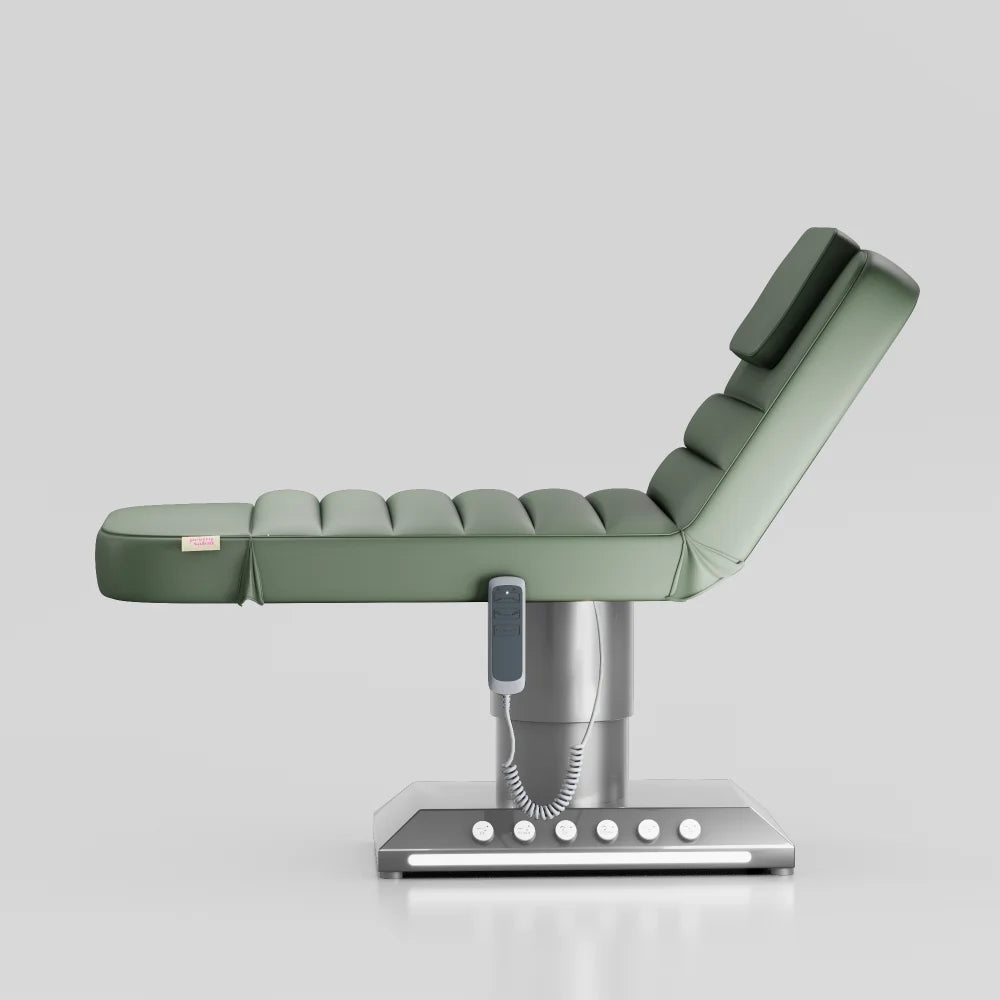 Sage green adjustable beauty bed with silver base and built in foot control for treatments